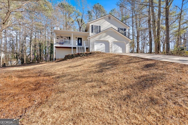 front of property with a garage, a front yard, and covered porch