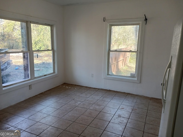 empty room with plenty of natural light and light tile patterned floors