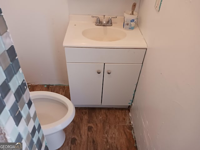 bathroom featuring vanity, hardwood / wood-style flooring, and toilet