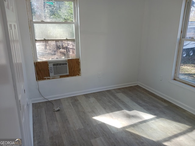 unfurnished room with cooling unit and wood-type flooring