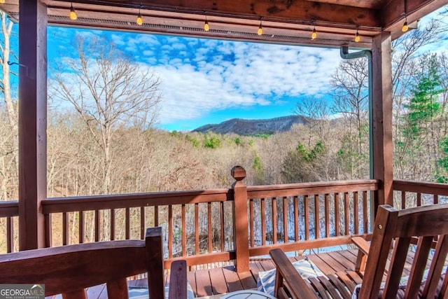 wooden terrace with ceiling fan and a grill