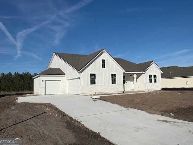 modern farmhouse style home featuring board and batten siding, concrete driveway, and a garage