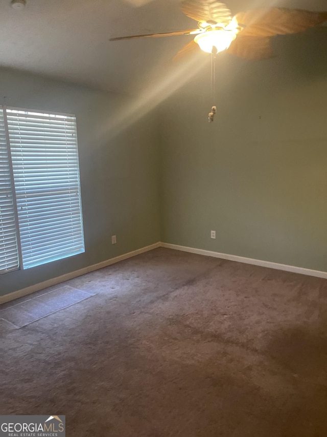 spare room with ceiling fan and carpet