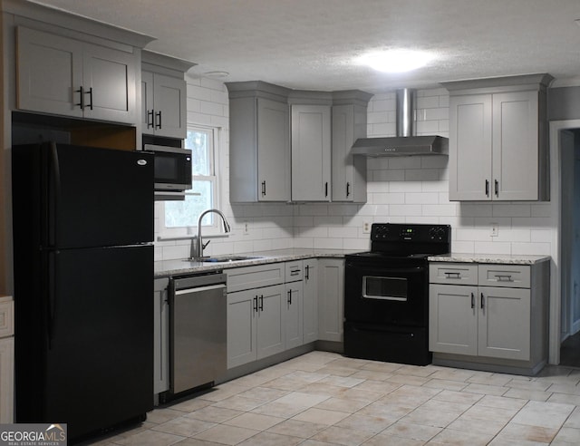 kitchen with sink, black appliances, wall chimney exhaust hood, and light stone countertops