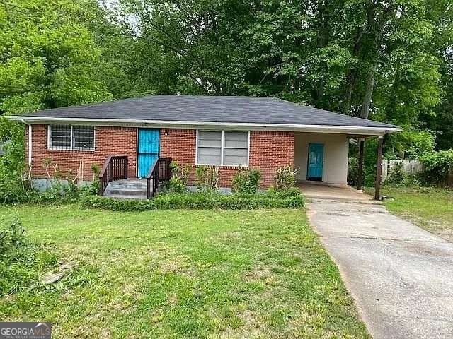 ranch-style house with a carport and a front yard