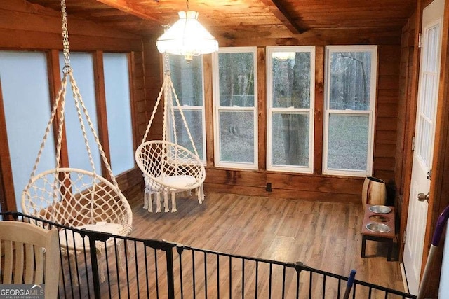 sunroom / solarium with lofted ceiling with beams, a notable chandelier, and wood ceiling