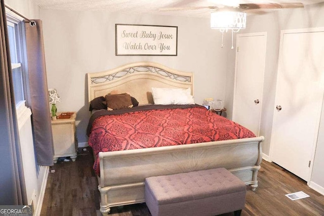 bedroom with dark hardwood / wood-style floors and ceiling fan