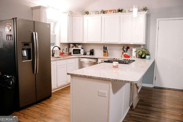 kitchen featuring sink, white cabinetry, light wood-type flooring, appliances with stainless steel finishes, and kitchen peninsula