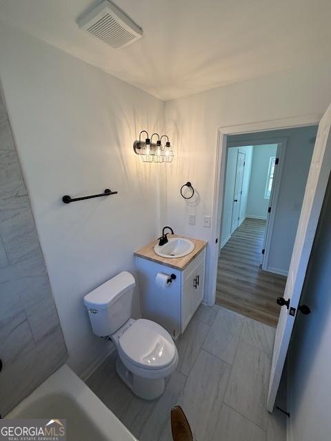 bathroom with vanity, toilet, and a bathtub