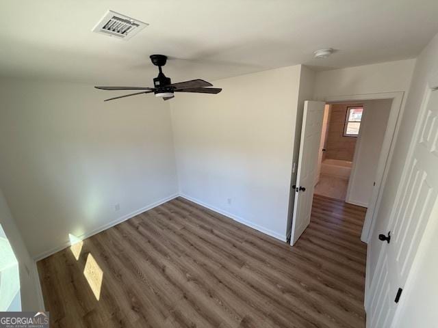 empty room with ceiling fan and dark hardwood / wood-style floors