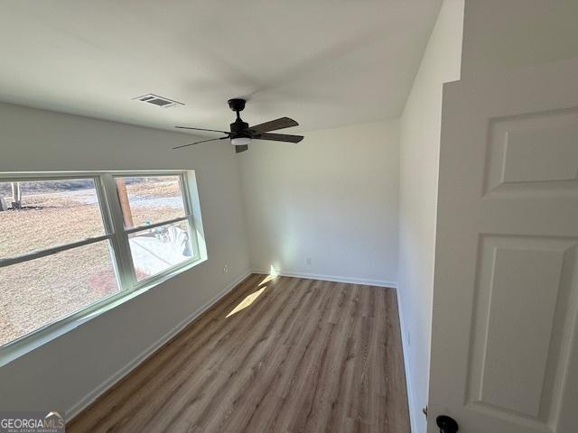 spare room with hardwood / wood-style flooring and ceiling fan