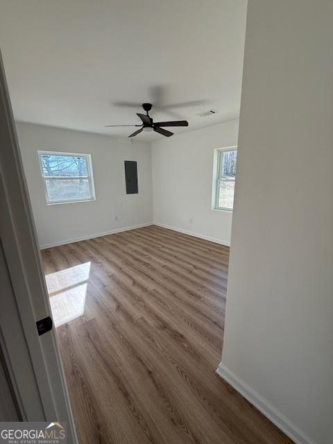 unfurnished room featuring hardwood / wood-style flooring, plenty of natural light, and ceiling fan