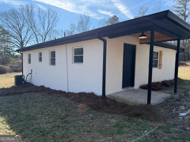 view of side of property featuring cooling unit and a yard