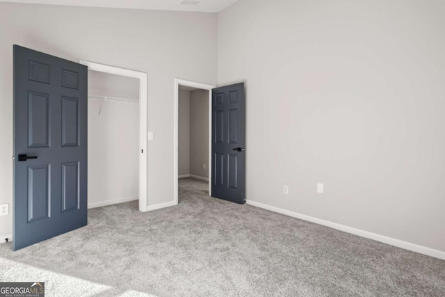 unfurnished bedroom with light colored carpet, a closet, and a towering ceiling