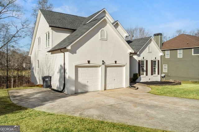 view of home's exterior with a lawn, roof with shingles, concrete driveway, a garage, and a chimney