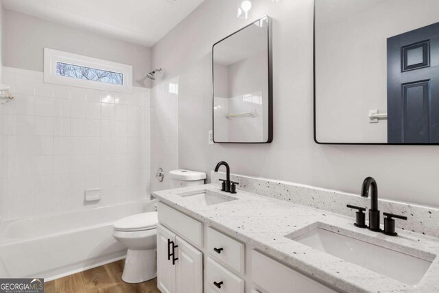 full bathroom featuring vanity, wood-type flooring, shower / washtub combination, and toilet