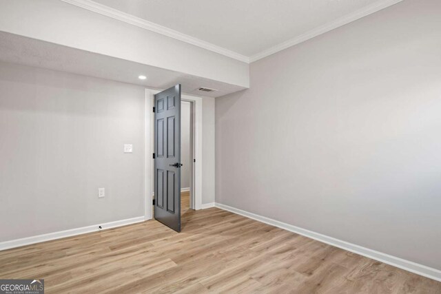 unfurnished room with crown molding and light wood-type flooring