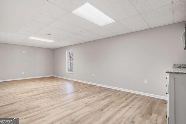 interior space with a drop ceiling and light wood-type flooring