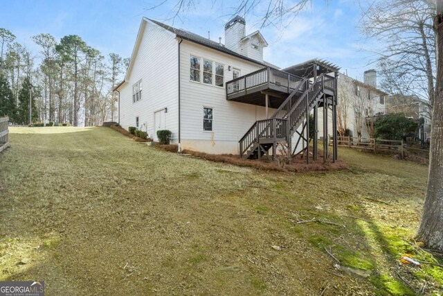 back of house featuring a wooden deck and a yard