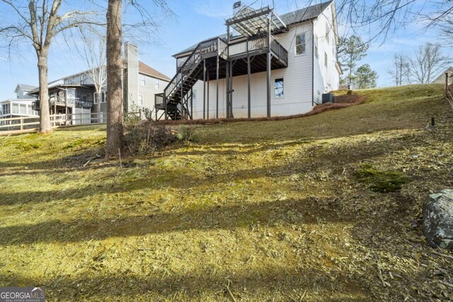 back of property with a yard, a deck, and central air condition unit