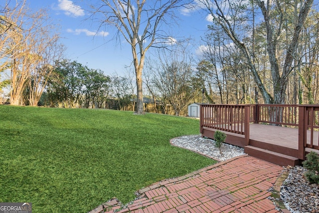 view of yard with a wooden deck and a storage shed