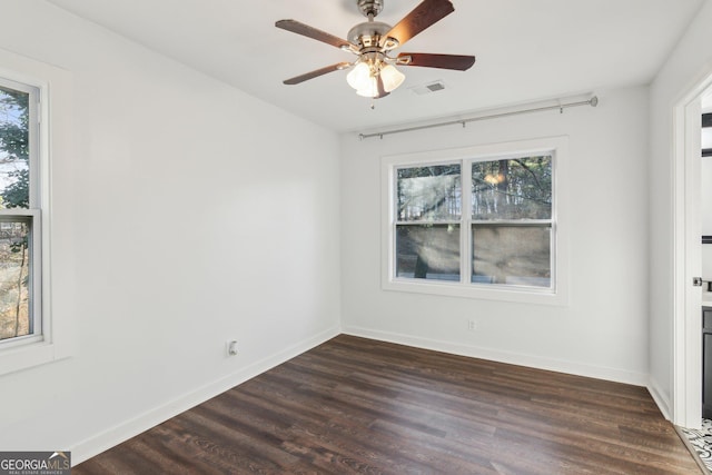 unfurnished room with plenty of natural light, dark hardwood / wood-style floors, and ceiling fan