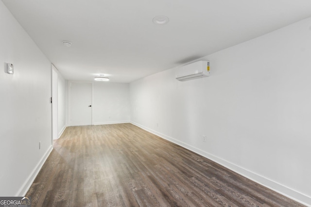 empty room featuring a wall mounted air conditioner and dark wood-type flooring