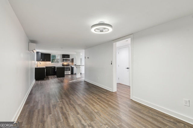 unfurnished living room featuring sink and dark wood-type flooring