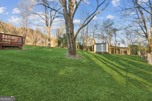 view of yard with a wooden deck and a storage shed