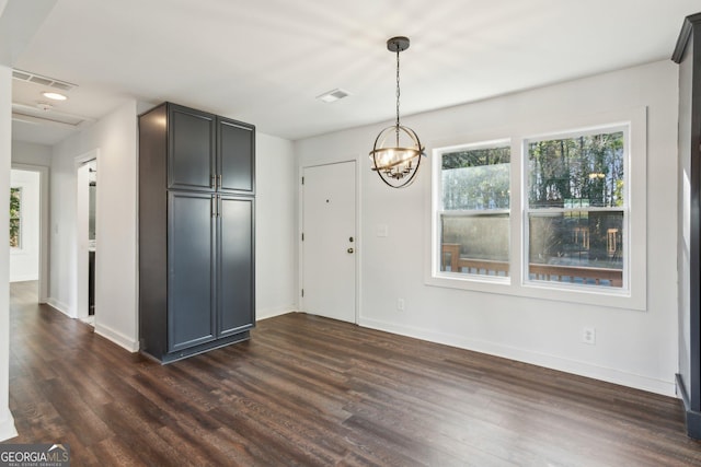 unfurnished dining area with dark hardwood / wood-style floors and a chandelier