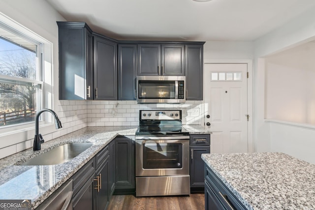 kitchen with tasteful backsplash, sink, dark hardwood / wood-style floors, and appliances with stainless steel finishes