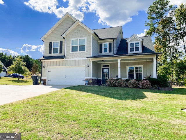 craftsman inspired home featuring a garage, covered porch, and a front lawn