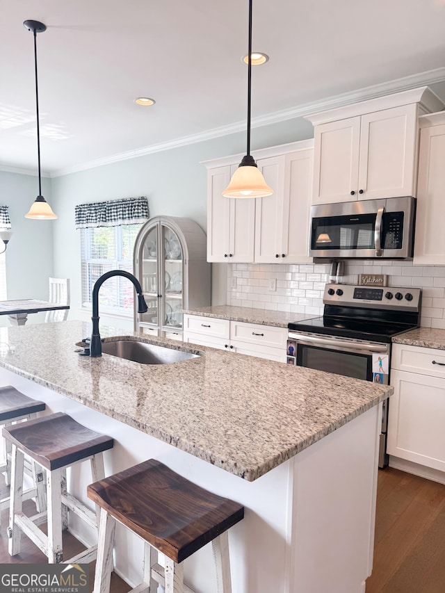 kitchen featuring crown molding, a sink, white cabinets, and stainless steel appliances