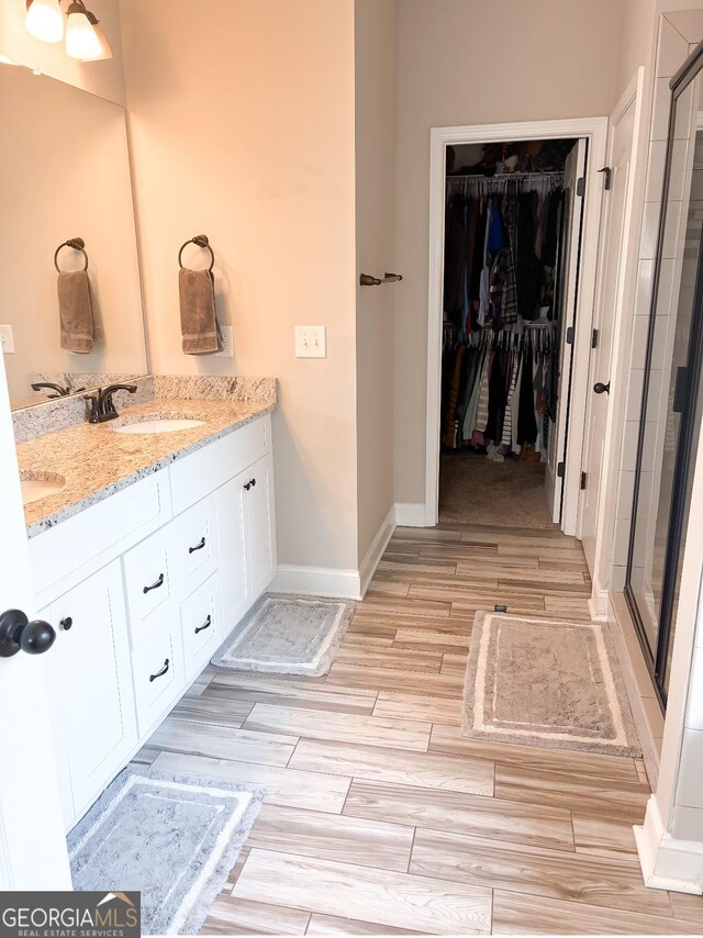 601HYDRANGEAL 601 Hydrangea Ln, Bremen, GA 30110 - bathroom with a shower stall, wood finished floors, double vanity, a walk in closet, and baseboards