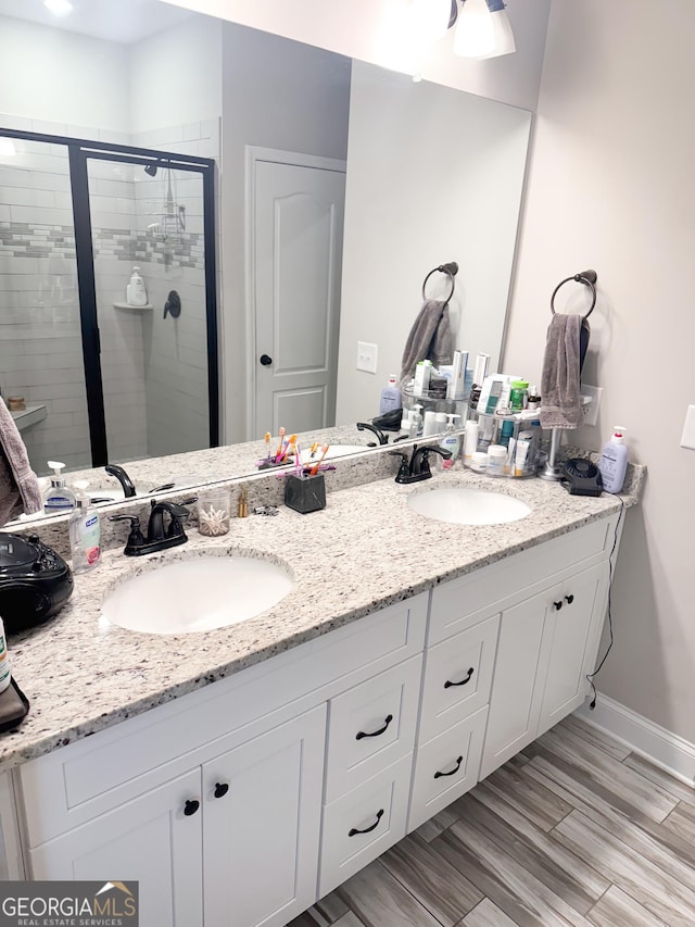 bathroom with walk in shower, wood-type flooring, and vanity