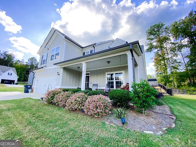 view of front of home featuring a garage, a front lawn, and covered porch