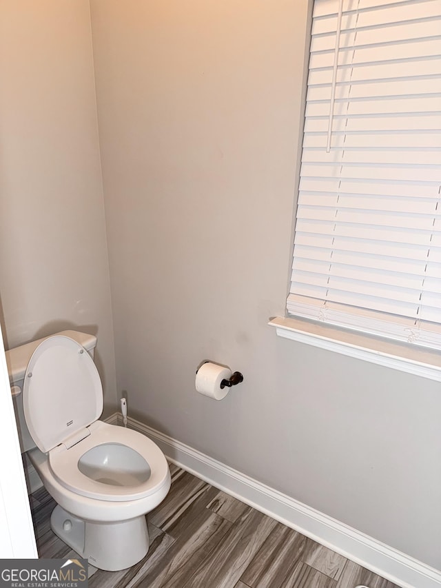 bathroom with hardwood / wood-style flooring and toilet