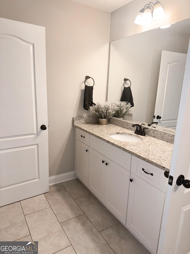 bathroom featuring baseboards, marble finish floor, and vanity