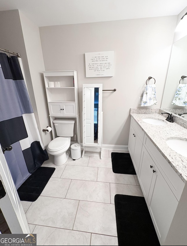 full bathroom featuring double vanity, toilet, baseboards, a shower with curtain, and a sink