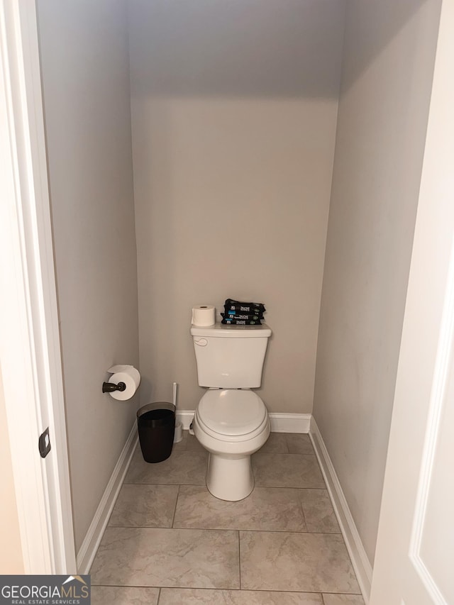 bathroom with toilet and tile patterned flooring