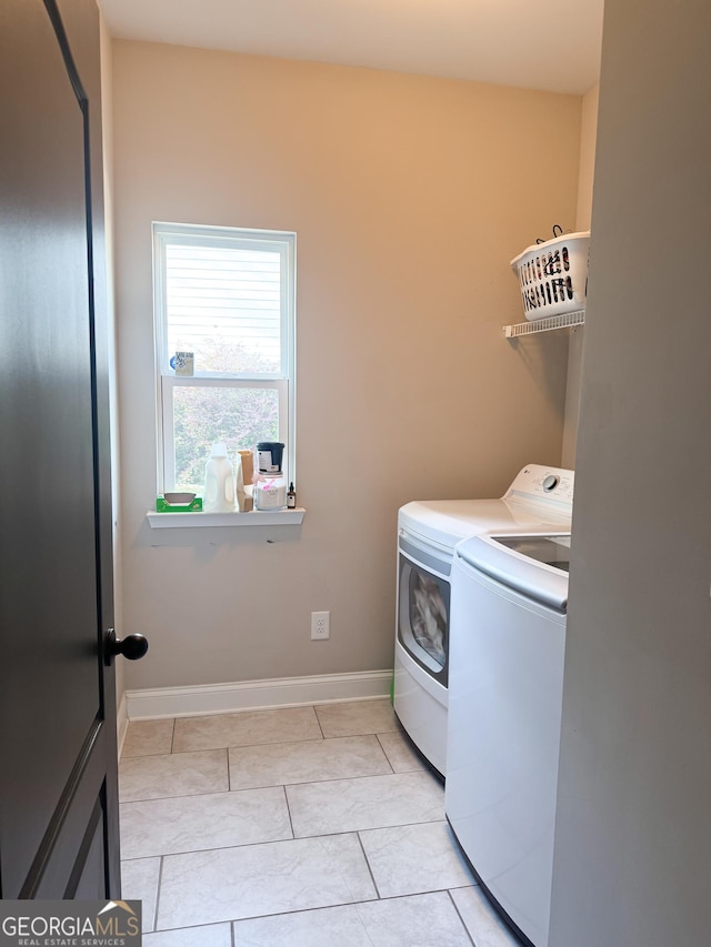 laundry room featuring laundry area, washer and clothes dryer, baseboards, and light tile patterned floors