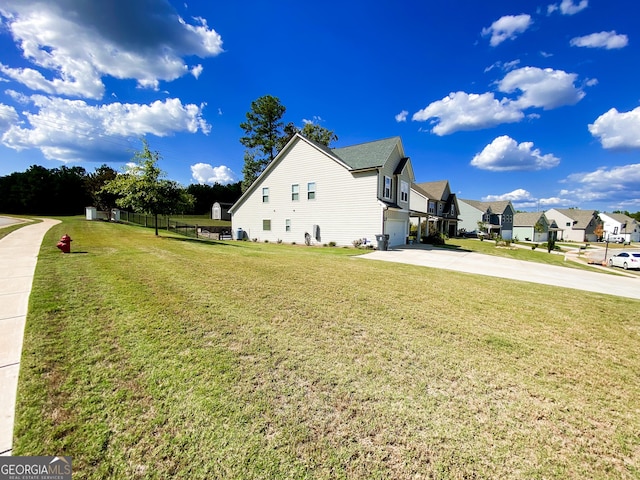 view of property exterior with a lawn, a garage, driveway, and a residential view