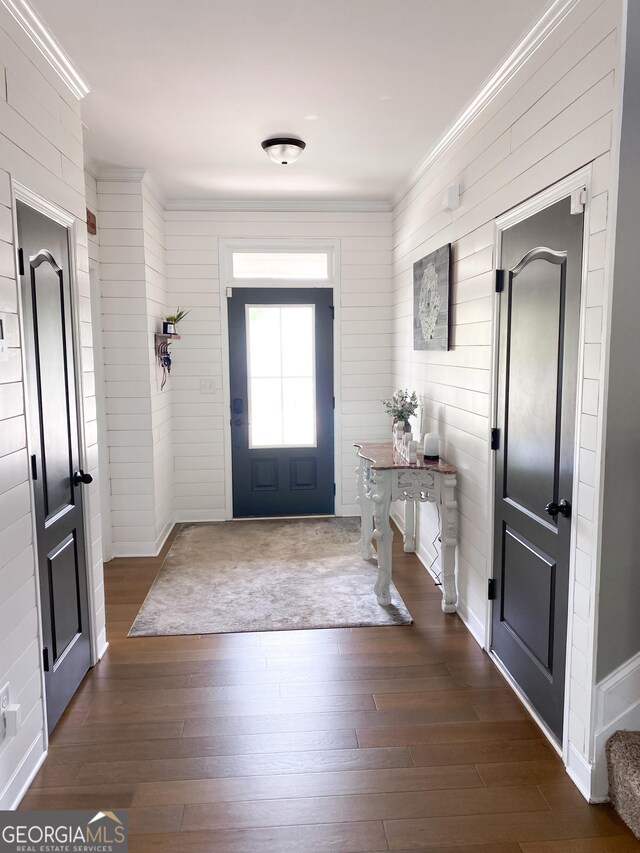 foyer entrance featuring dark wood-type flooring and ornamental molding