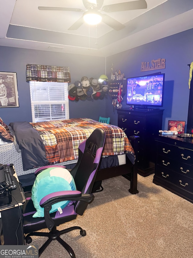 bedroom featuring ceiling fan, carpet flooring, and a raised ceiling