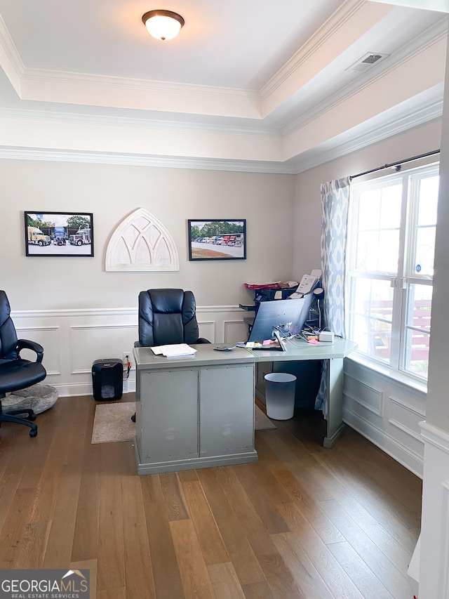 office space with a tray ceiling, wood-type flooring, and ornamental molding