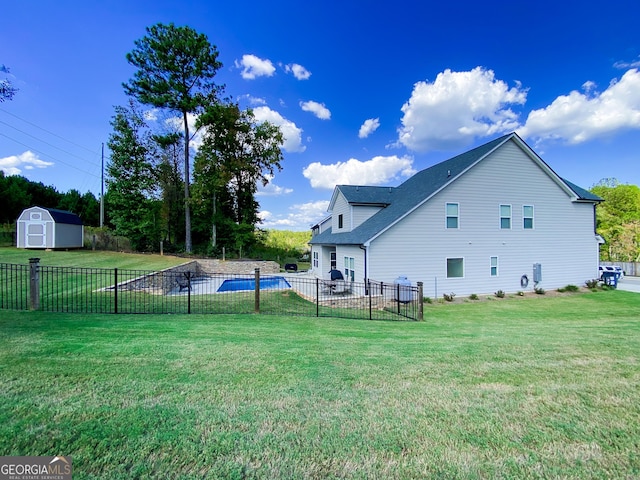 exterior space featuring fence, an outbuilding, a yard, and a shed