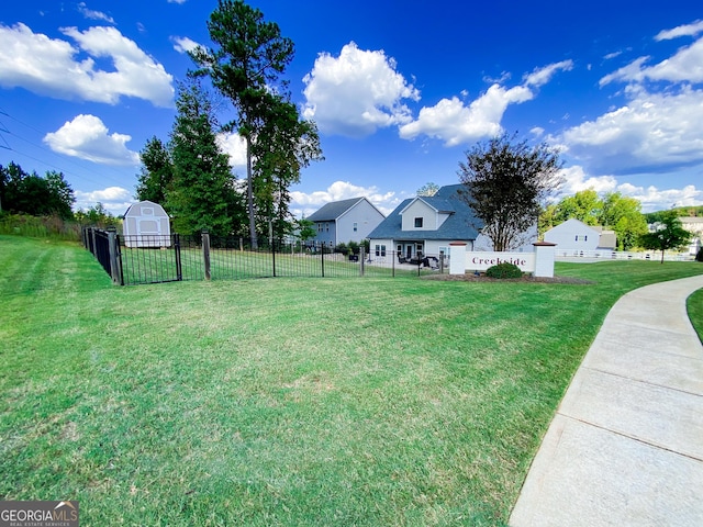 view of yard featuring a storage unit, fence, and an outbuilding