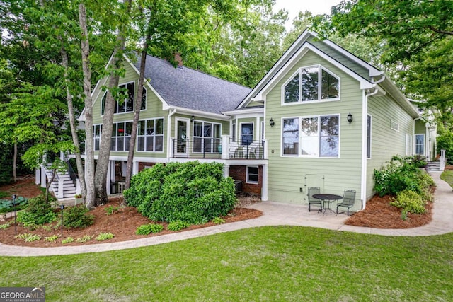 rear view of house featuring a yard and a patio area