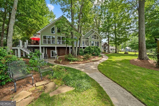 view of front of property with a wooden deck and a front lawn