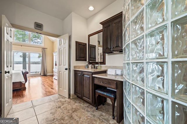 kitchen with light tile patterned flooring, dark brown cabinetry, and sink